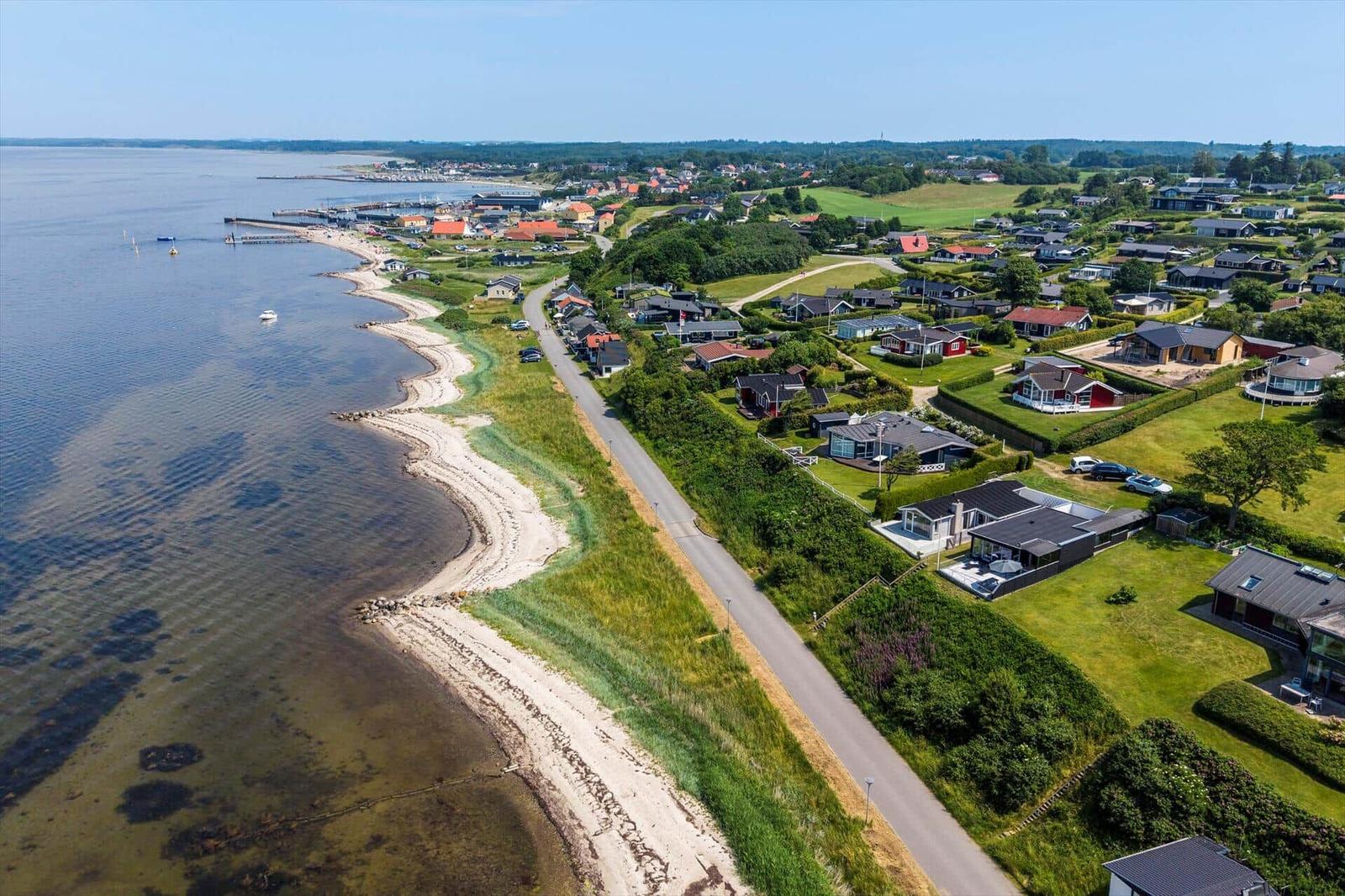 Aerielansicht einer Küstenlandschaft mit Häusern, Strand und Wasser.