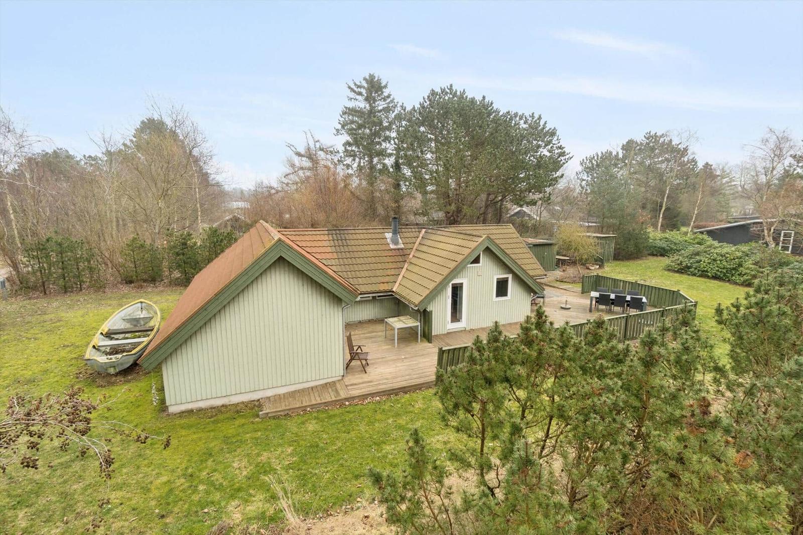 Ein Haus mit Terrasse, Garten und Boot auf dem Grundstück.