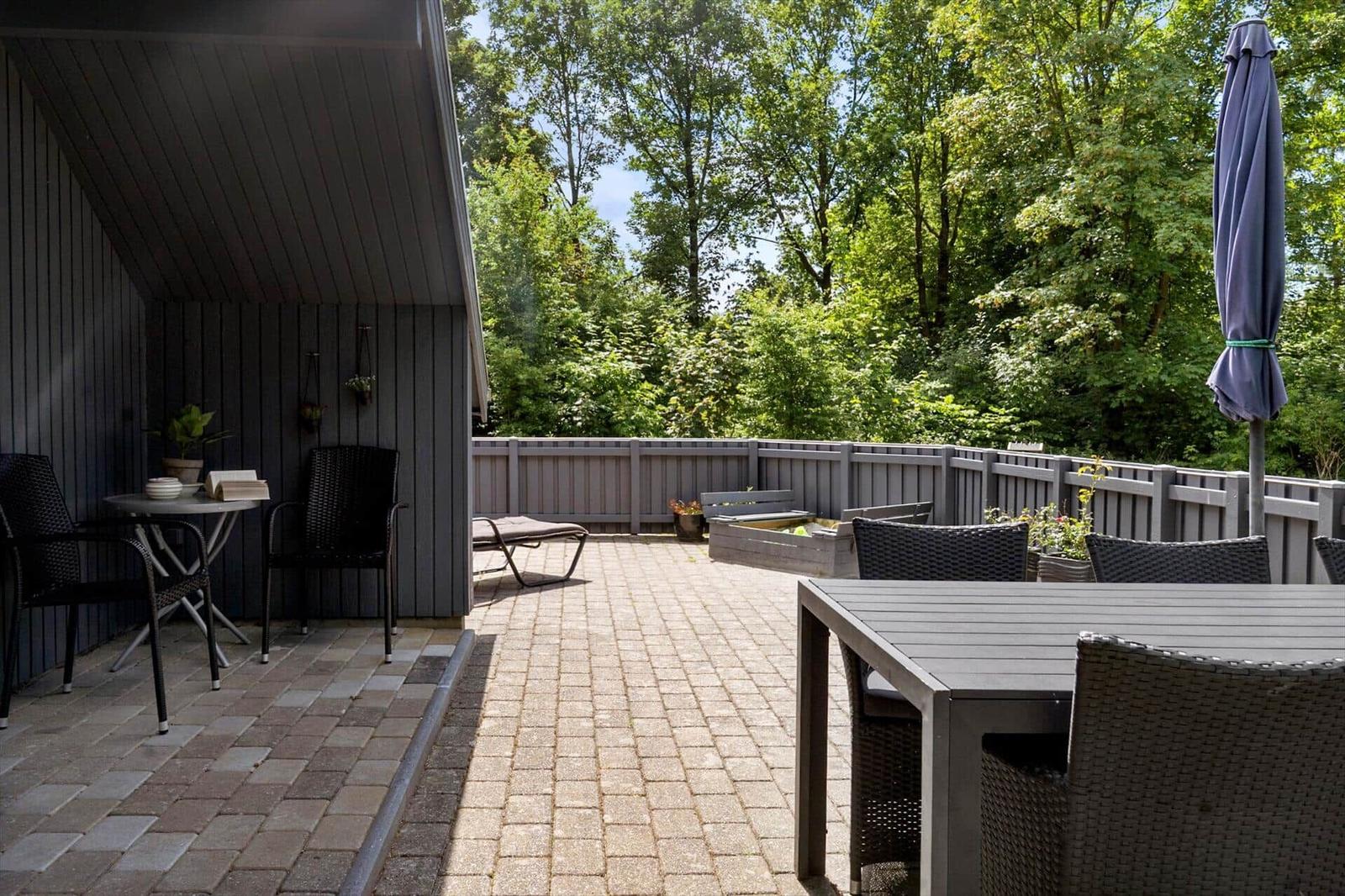 Terrasse mit Sitzgelegenheiten und Blick in den Wald.
