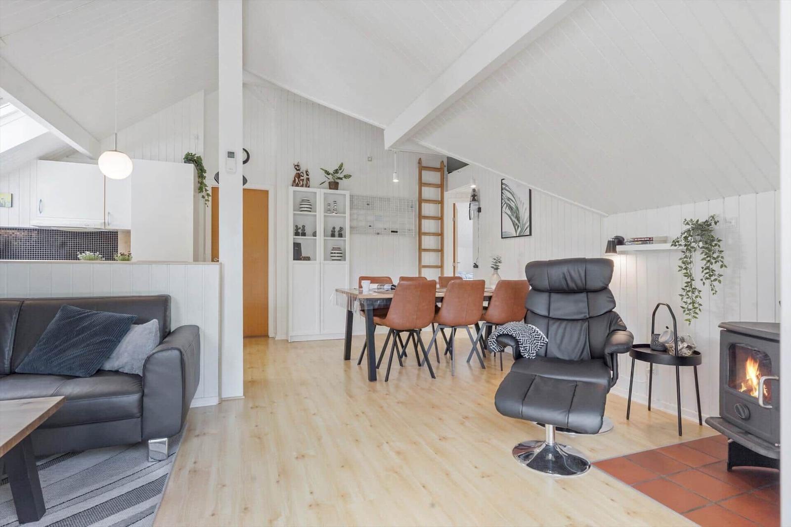 Wohn- und Essbereich mit Kamin, Sofa, Esstisch und Holzboden.