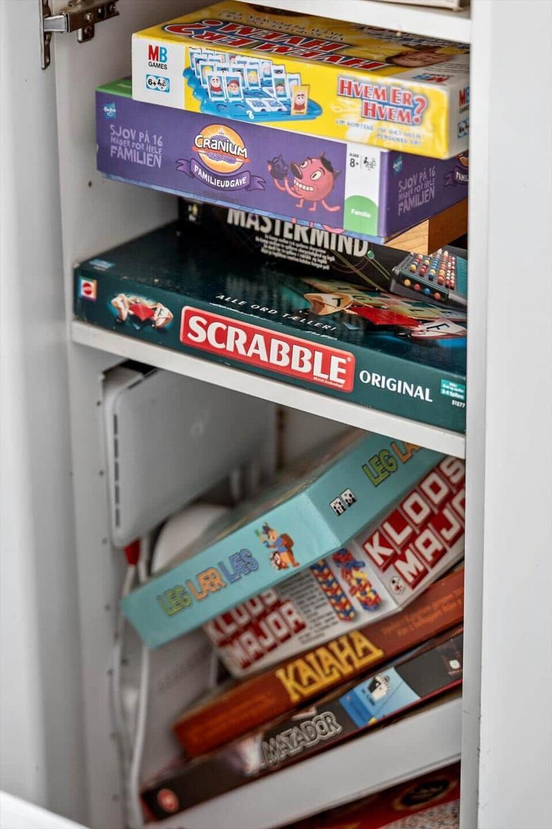 Schrank mit Brettspielen wie Scrabble und Mastermind.