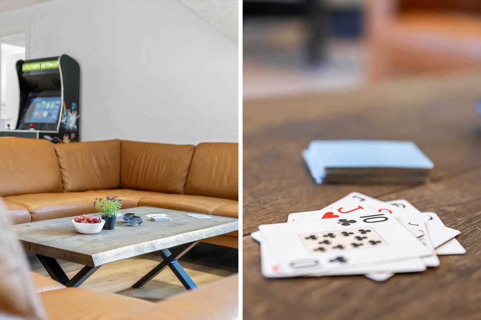 Lounge mit Ledersofa und Spielautomat. Tisch mit Karten und Obst.