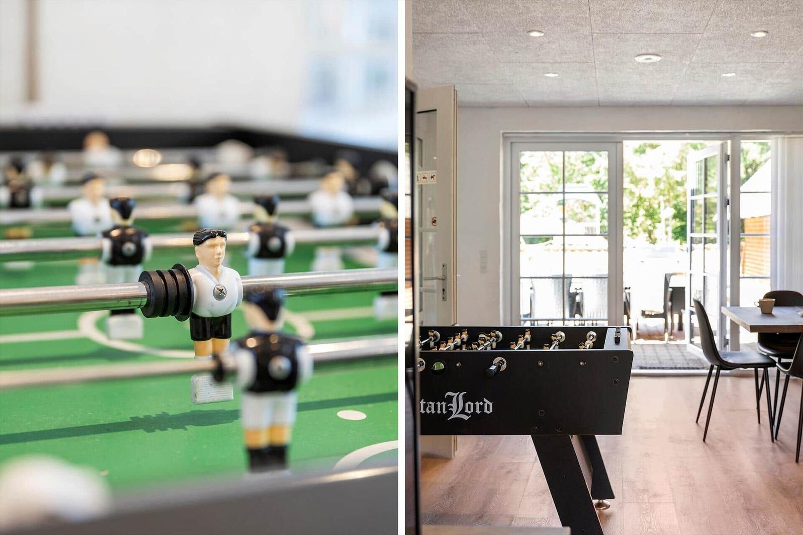 Fussballtisch mit Spielern im Innenraum. Hintergrund zeigt Terrasse mit Tisch und Stühlen.