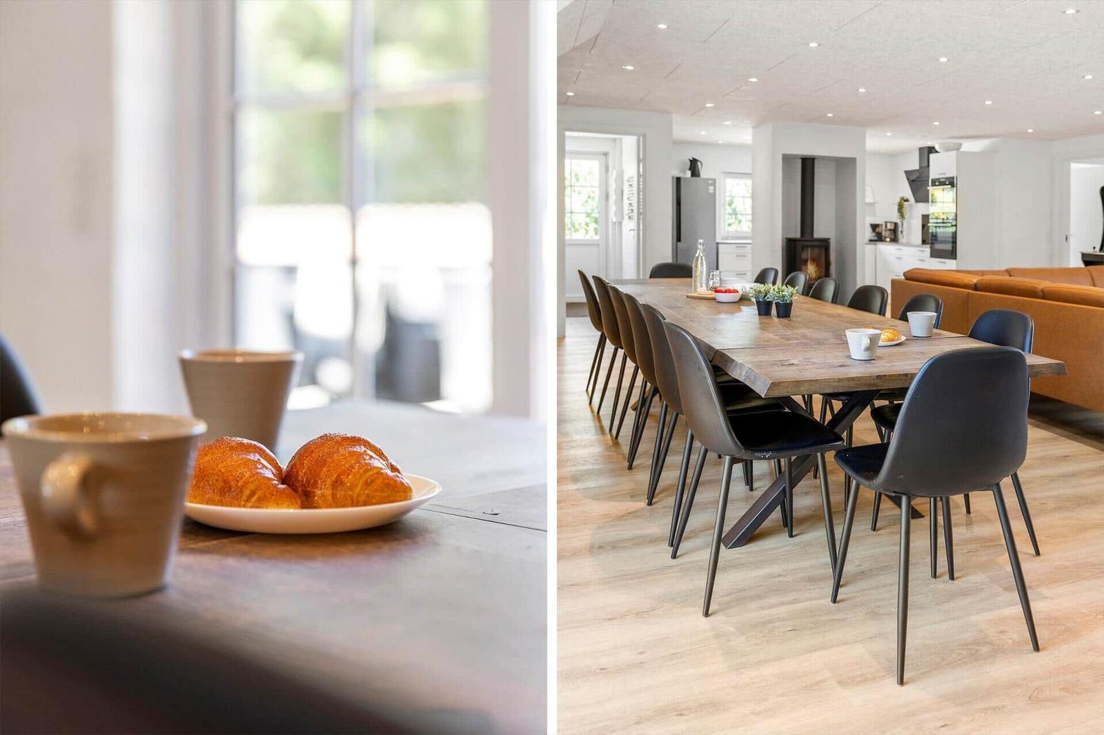 Esszimmer mit langem Holztisch und schwarzen Stühlen. Im Hintergrund Küche und Wohnbereich.