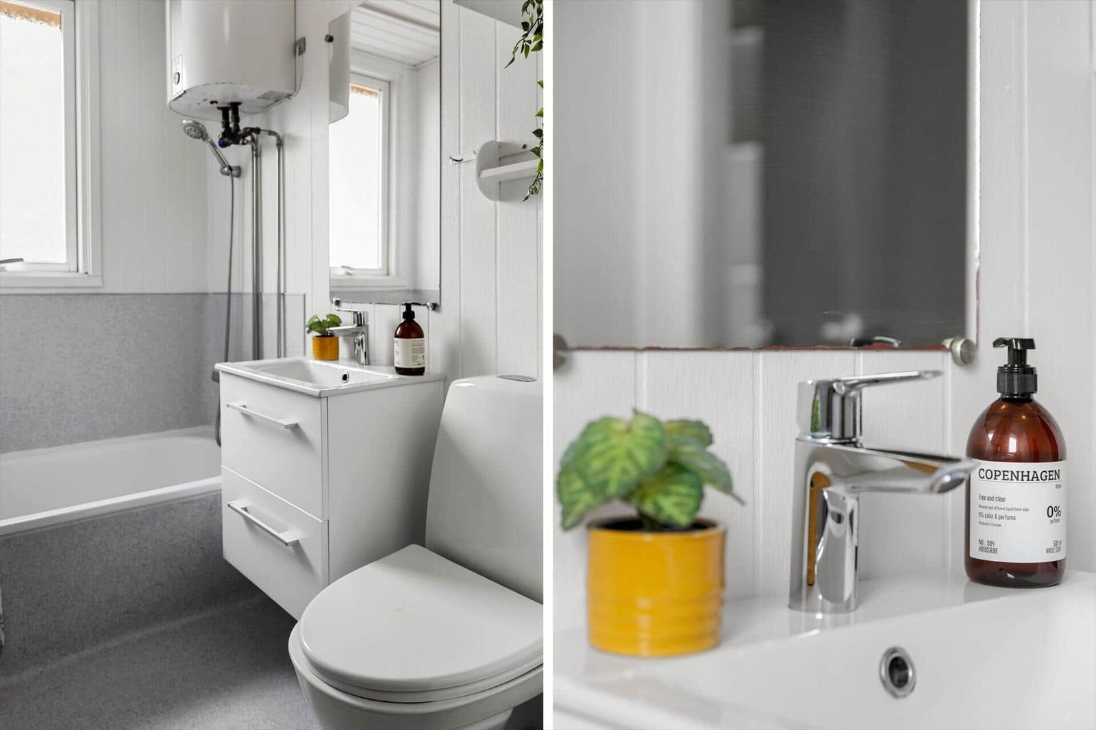 Badezimmer mit Badewanne, Waschbecken und Toilette. Gelbe Pflanze und Seife auf dem Waschtisch.