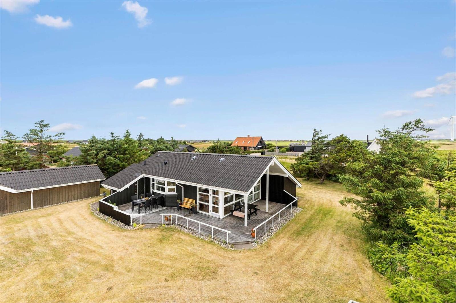 Moderne Villa mit Terrasse, Garten und Blick auf die Landschaft.