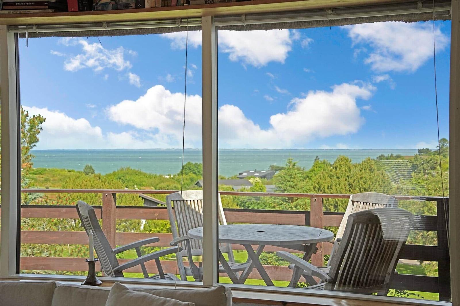 Deck with table and chairs offers ocean view.