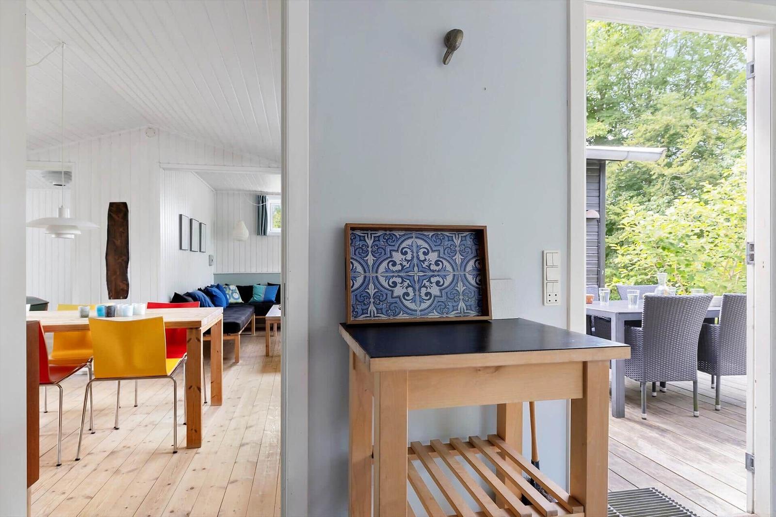 House with dining area, terrace, and blue-white tile artwork on the wall.