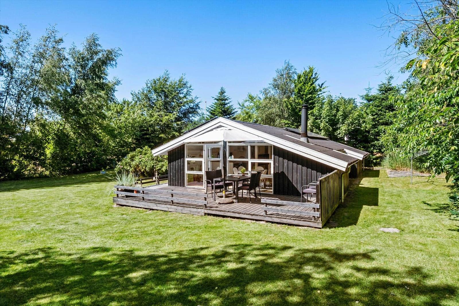 Hütte mit Terrasse, Garten und Grillplatz. Holzterrasse mit Sitzgelegenheit.