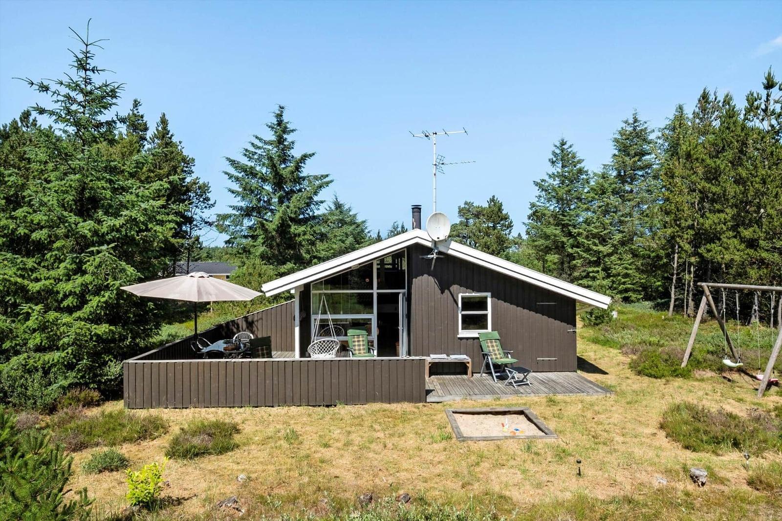 Holzhaus mit Terrasse, Garten und Spielplatz im Wald