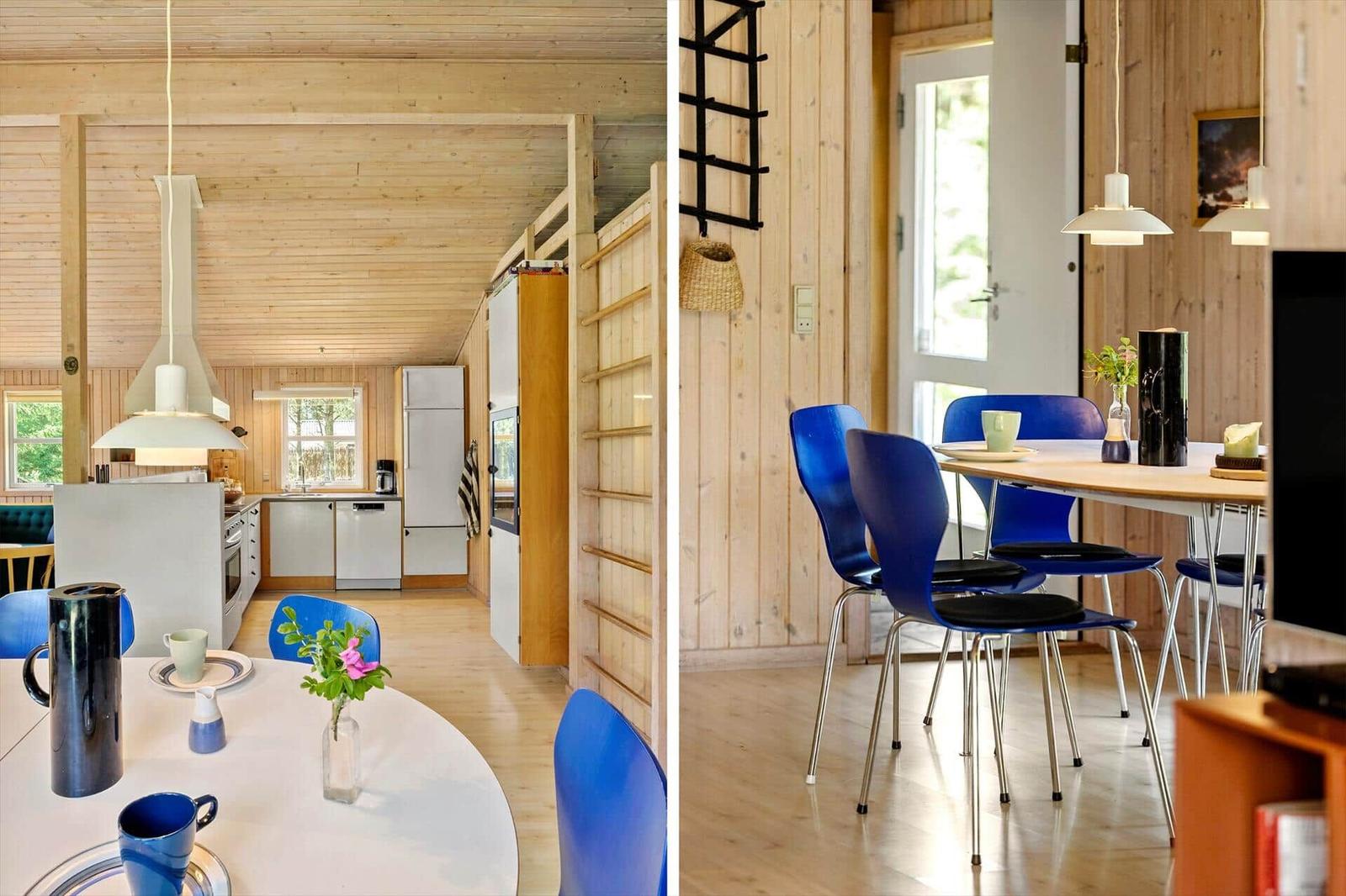 Küche und Essbereich mit Holzwänden, blauen Stühlen und moderner Einrichtung.