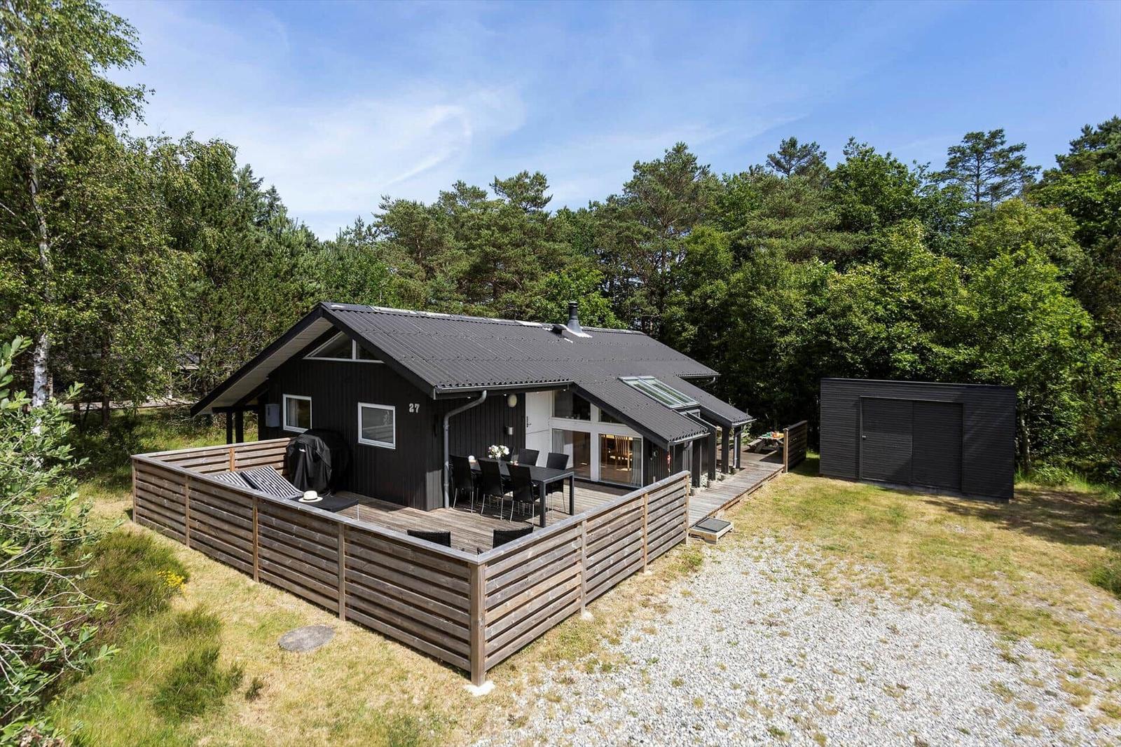 Moderne Holzhütte mit Terrasse, Grill und Garten. Umgeben von Wald und klarer Luft.