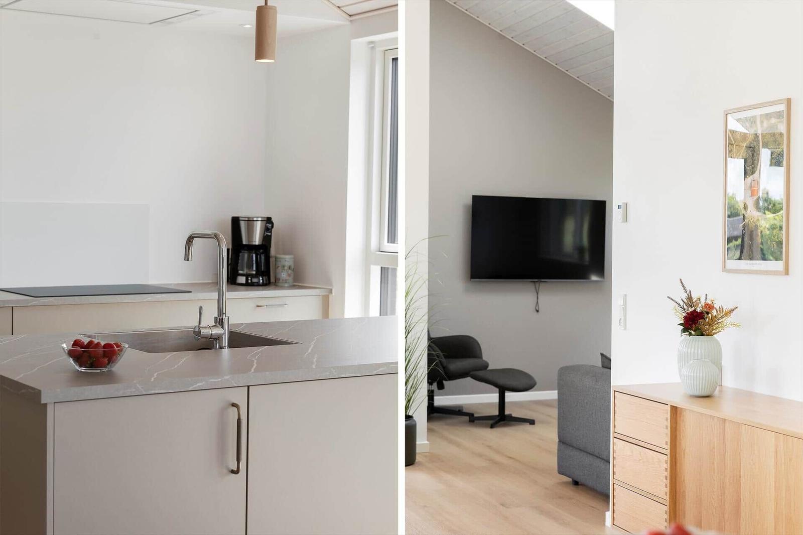 Küche mit Arbeitsplatte und Spüle. Wohnbereich mit Fernseher und Sitzgelegenheiten.