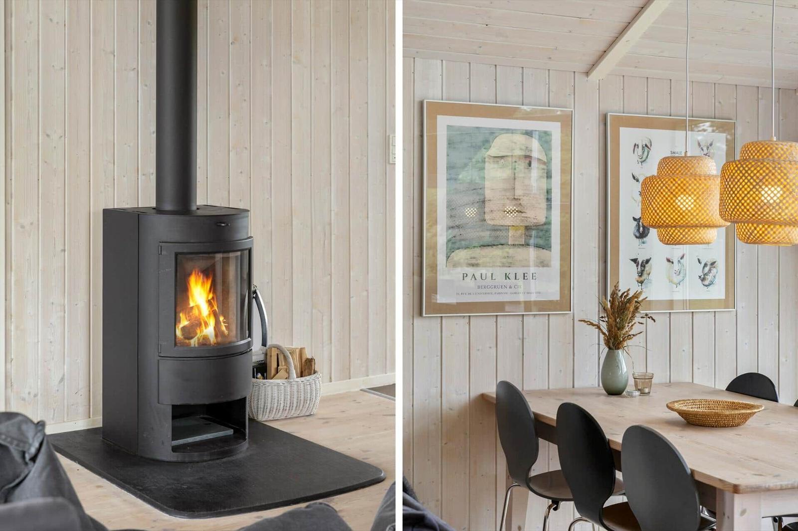 Kaminofen mit Brennholz und Essbereich mit Tisch und Stühlen an Holzwand.
