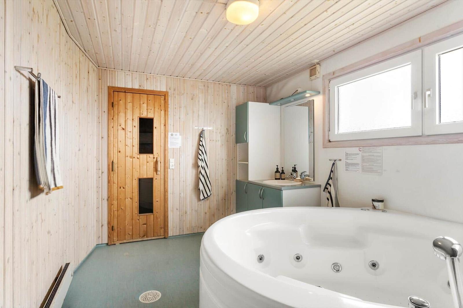 Badezimmer mit Whirlpool, Holzwand und Dusche