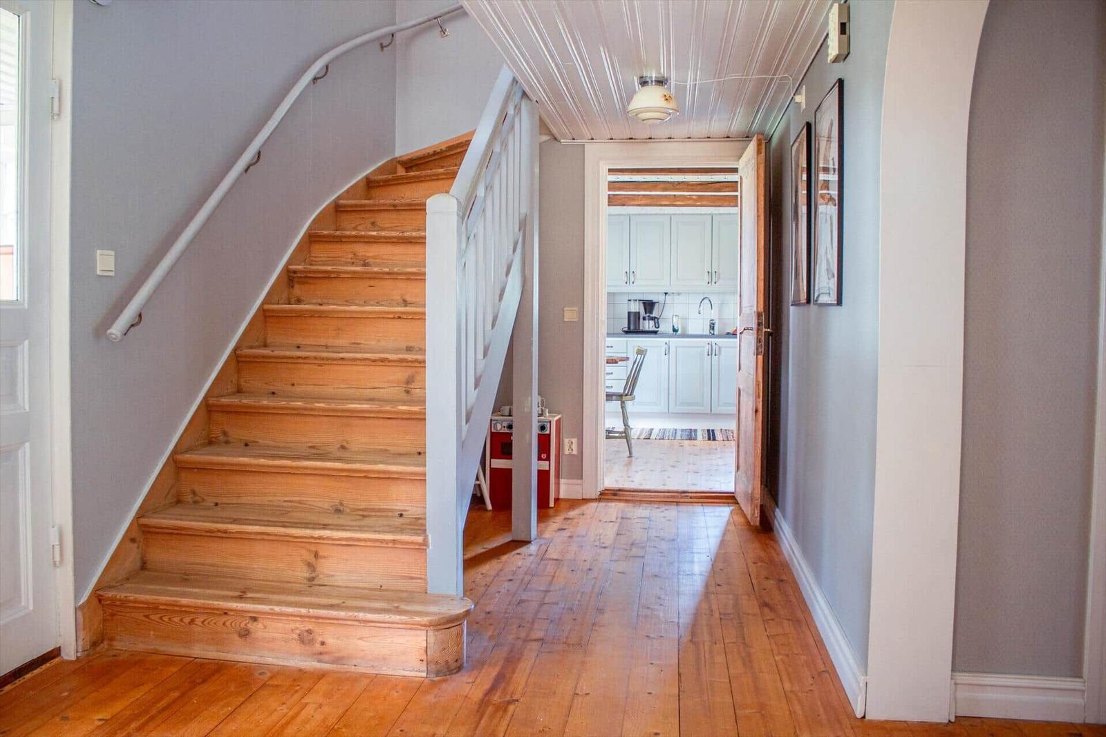 Haus mit Holztreppe und Küchenansicht durch offene Tür