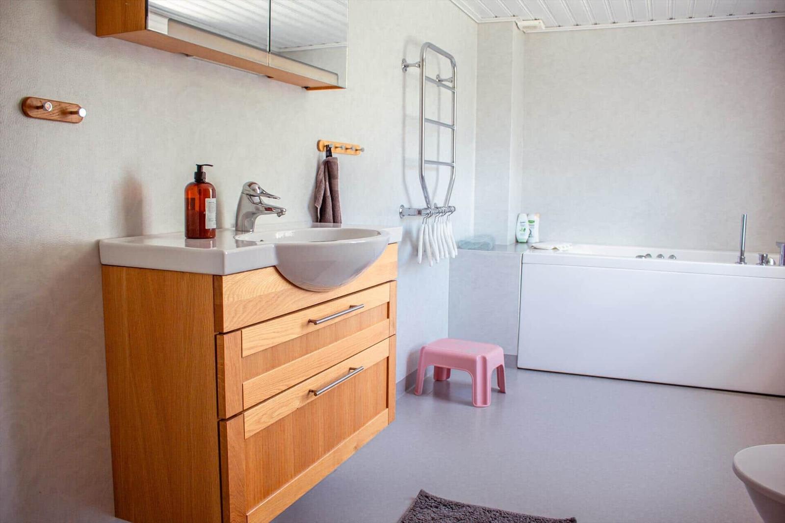 Bad mit Waschbecken, Duschbereich und Badewanne.