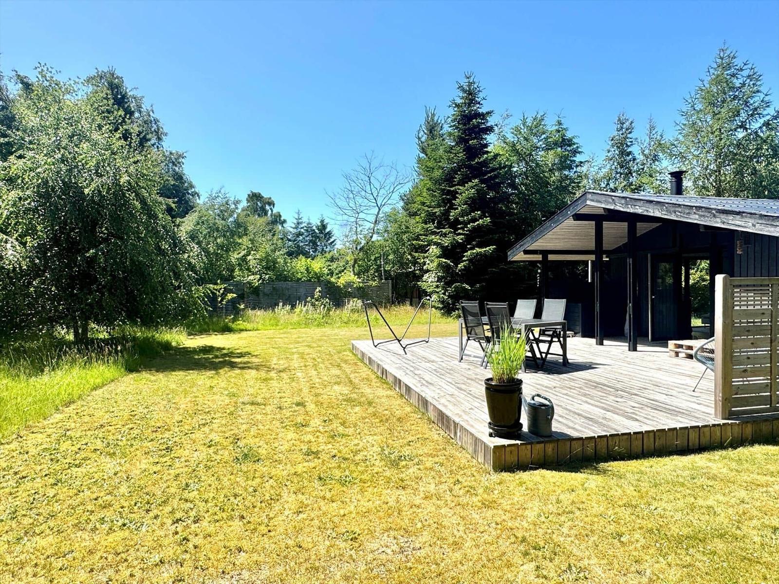 Haus mit Terrasse, Garten und Sitzgelegenheiten unter freiem Himmel.
