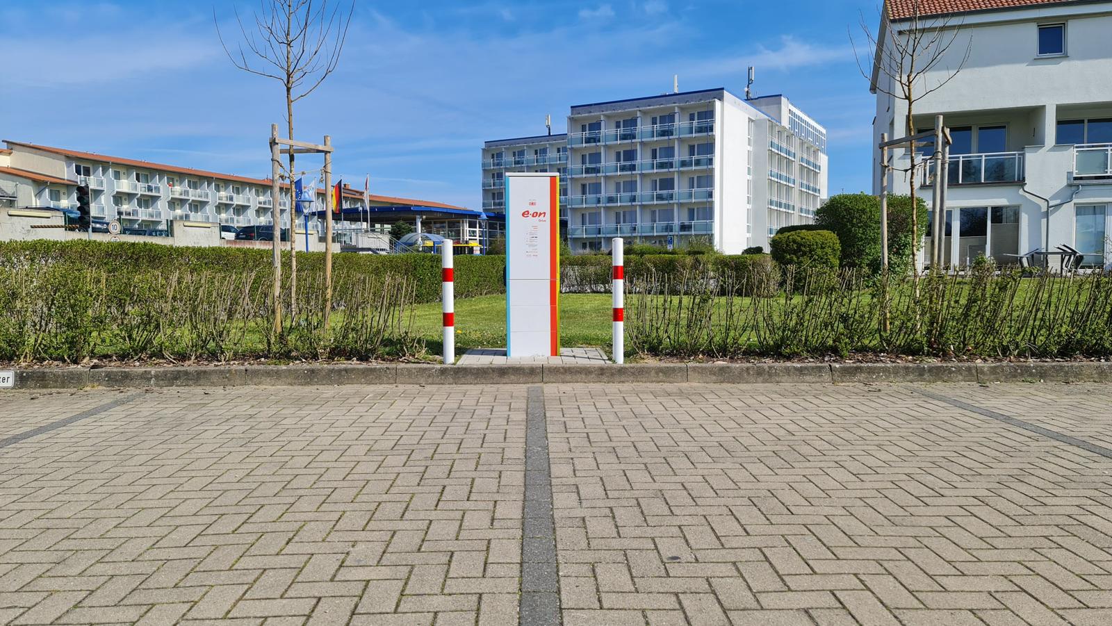 Energy supply unit with red and white posts in the garden area.