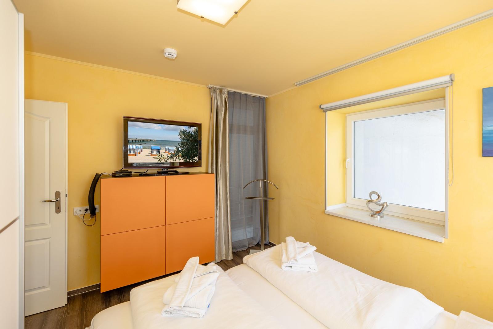Schlafzimmer mit Bett, Fernseher und Fenster