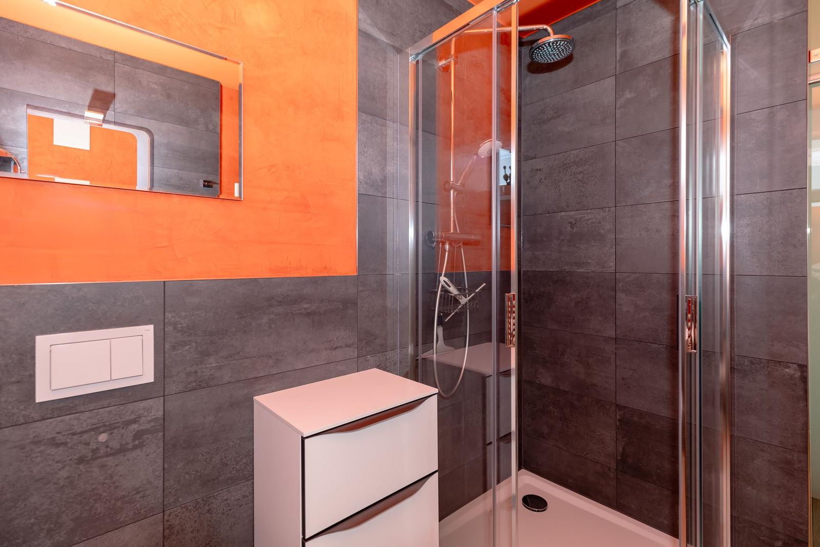 Badezimmer mit Dusche, Spiegelschrank und Waschbecken