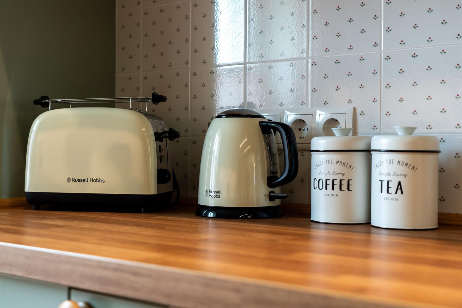 Küchenzeile mit Toaster, Kaffeekanne und Aufbewahrungsdosen für Kaffee und Tee.