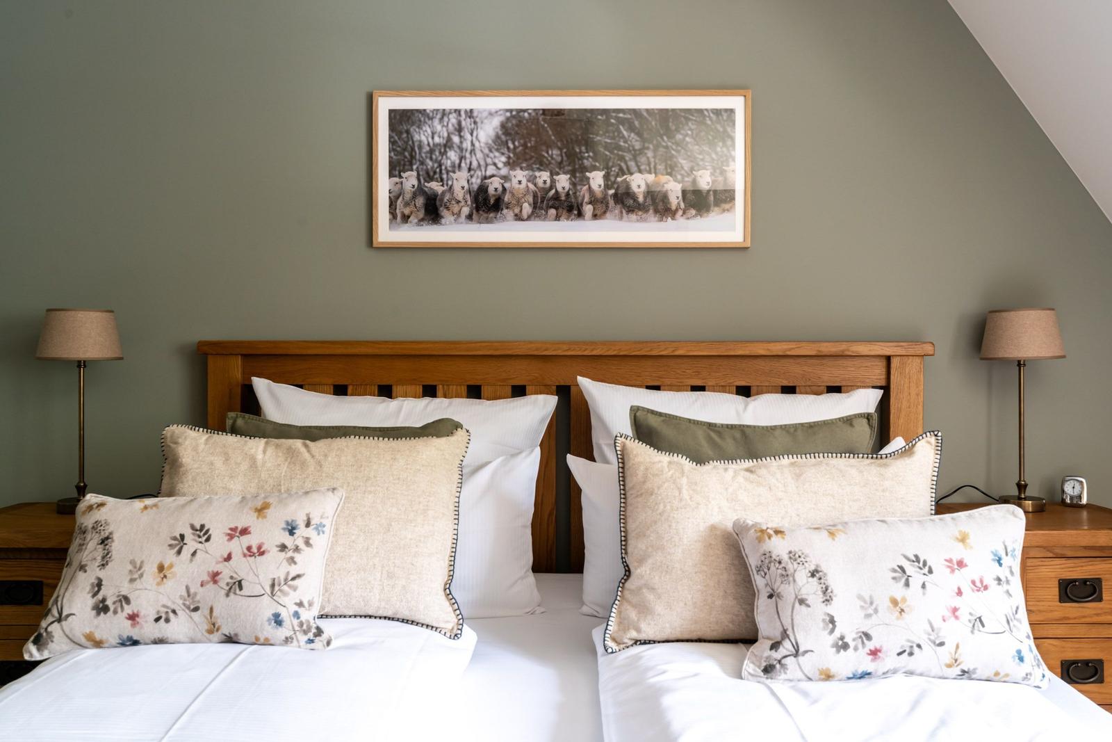 Schlafzimmer mit Holzbett, Kissen und Bild an der Wand.