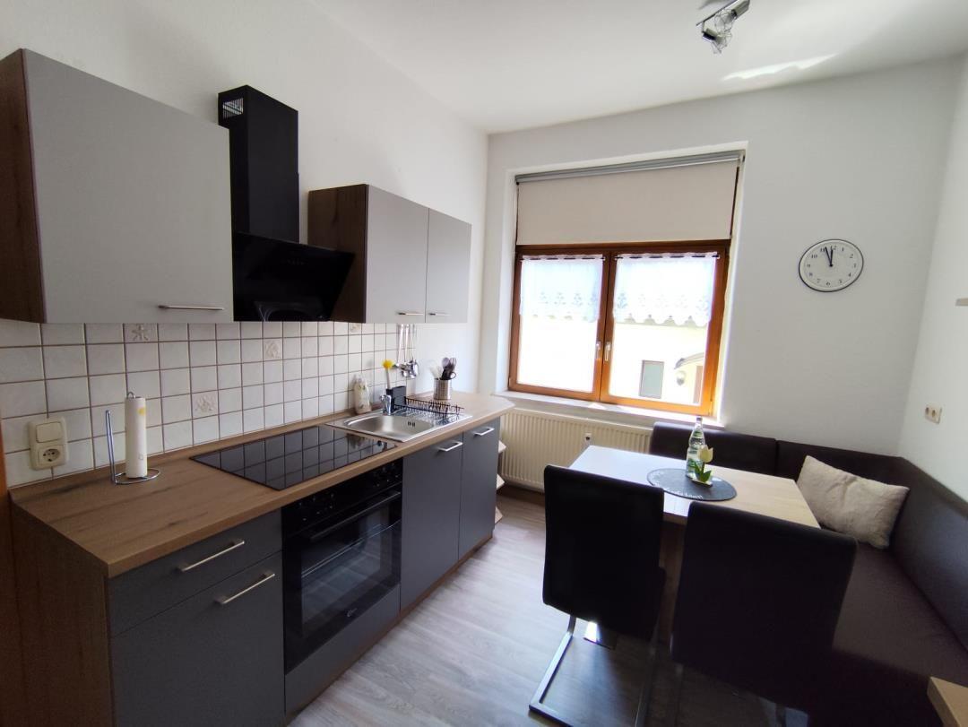 Kitchen with dining area, window, and wall clock