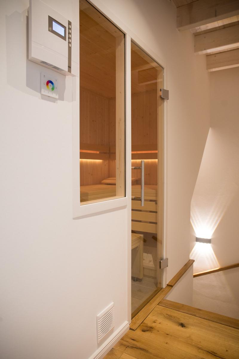 Sauna mit Holzwand und Glasfront, Steuerung an der Wand