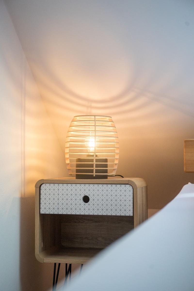 Nachttisch mit Schublade und Lampe neben dem Bett