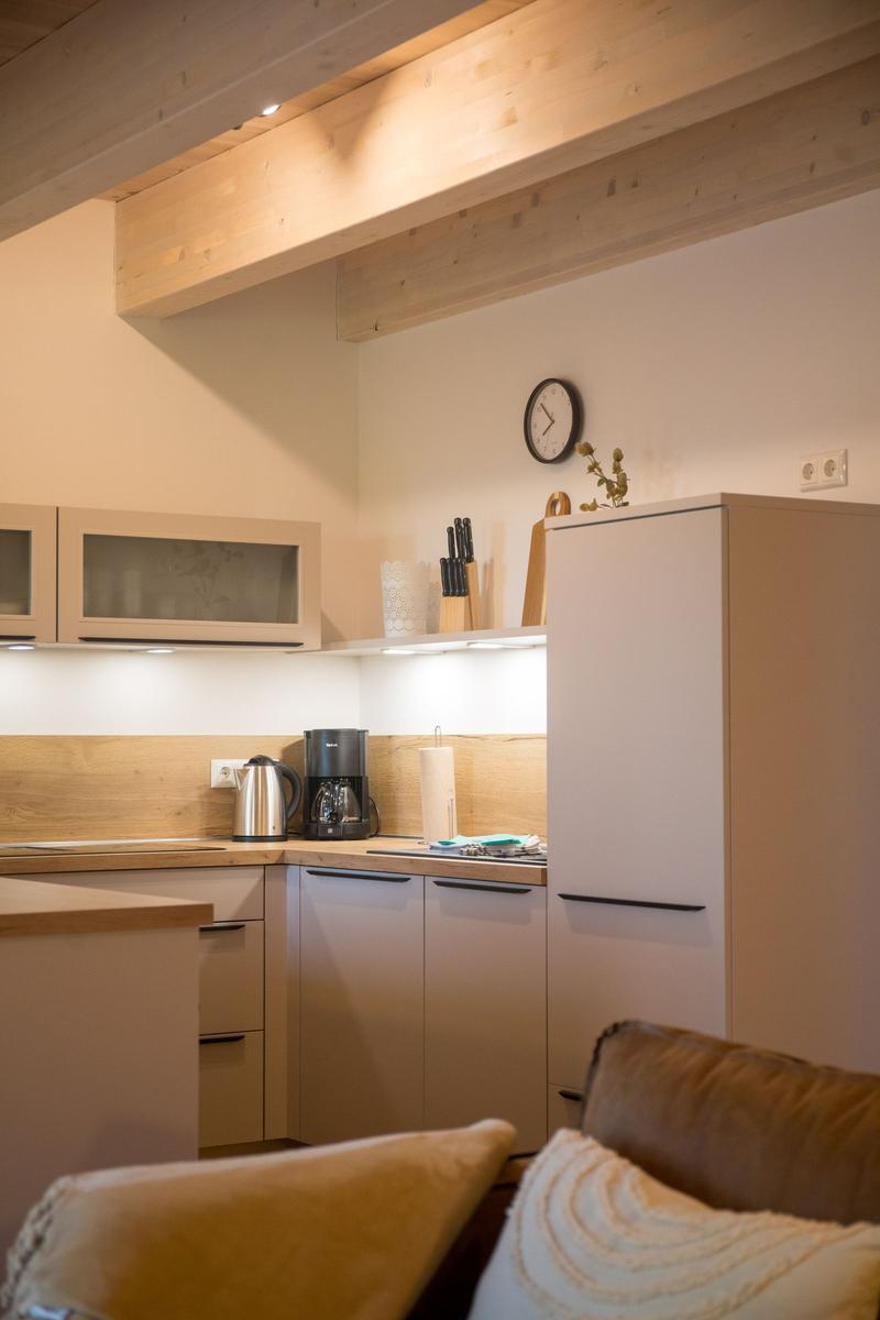 Küche mit Holzbalken, Kühlschrank und Kaffeemaschine