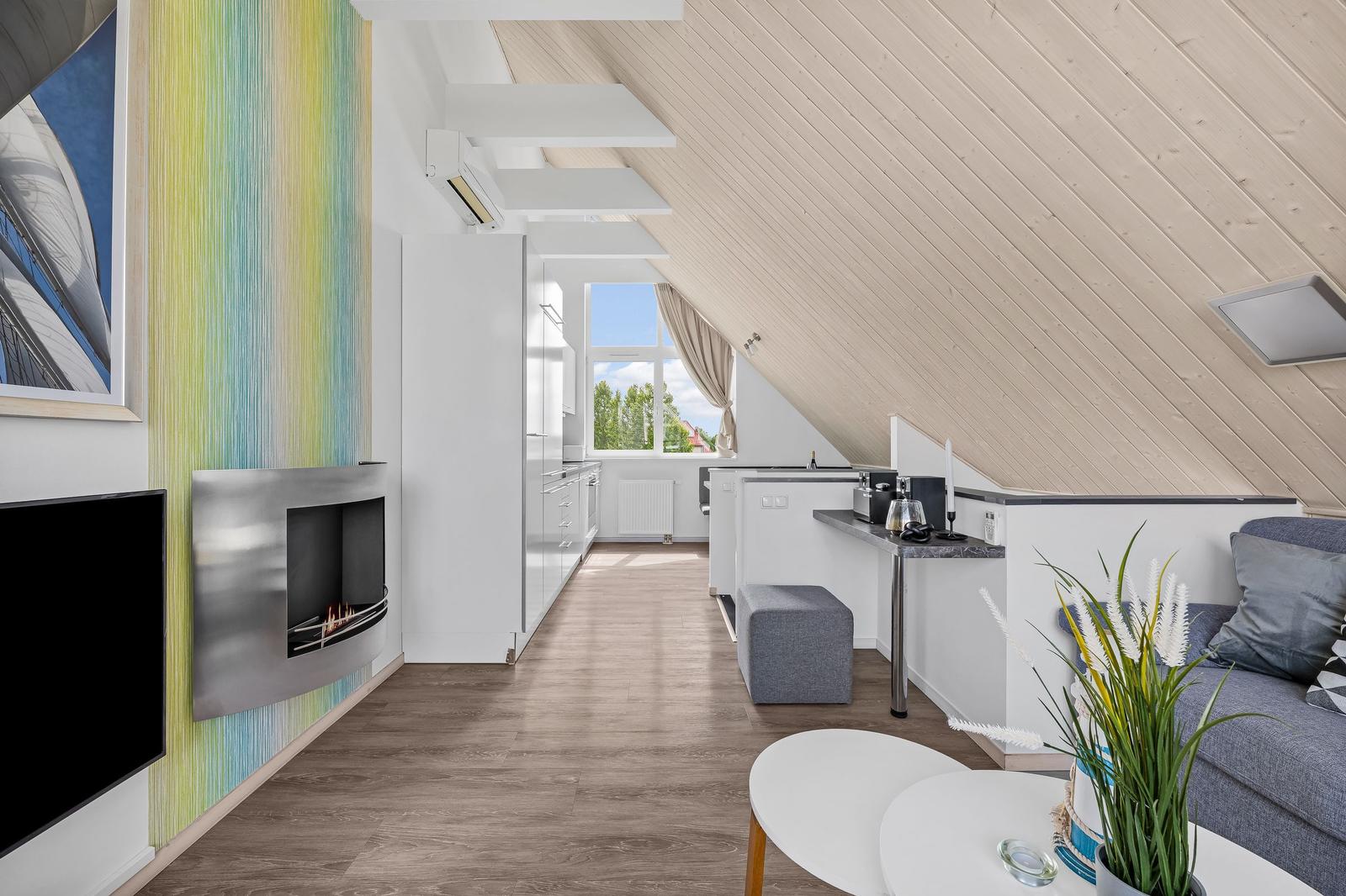 Wohnung mit Wohnbereich, Küche und Kamin in Dachschrägen