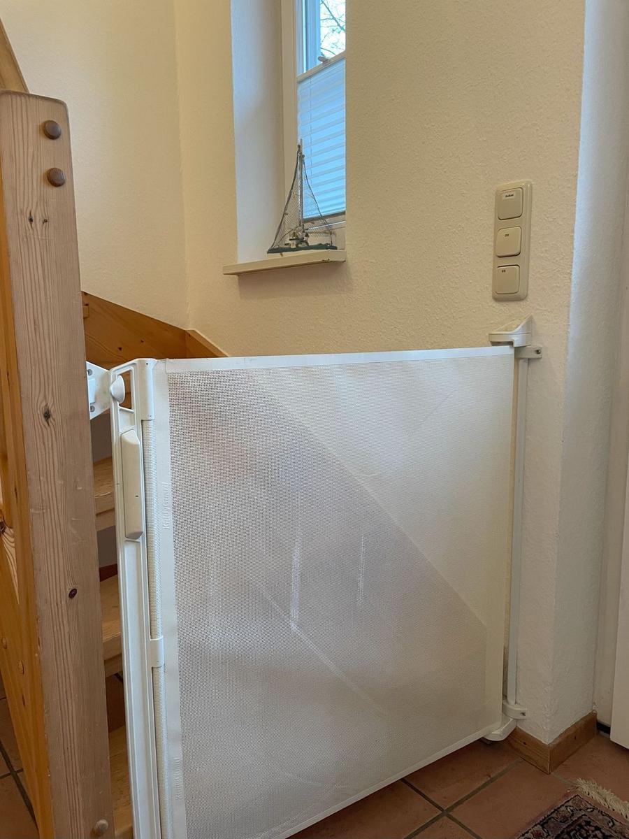 Kindersicherheitsgitter vor Treppenhaus mit Fenster und Steuerelementen an Wand