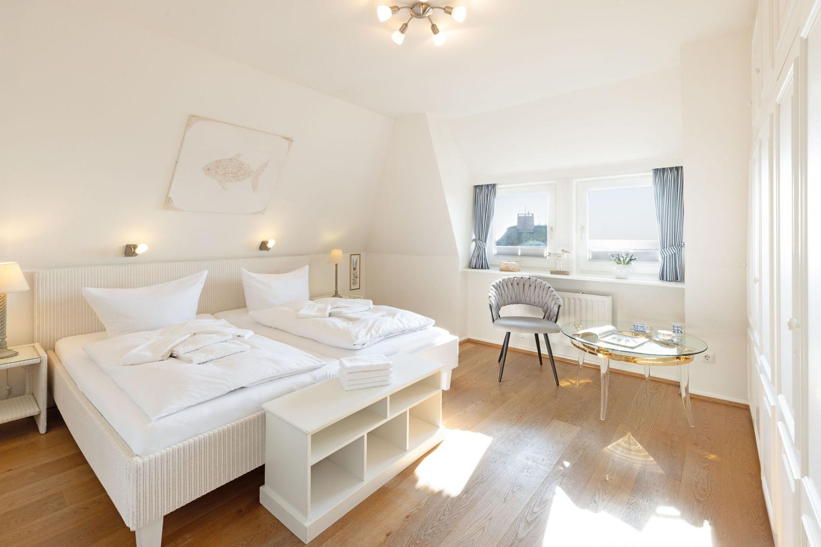 Schlafzimmer mit Doppelbett, Schreibtisch und Fenster mit Blick.