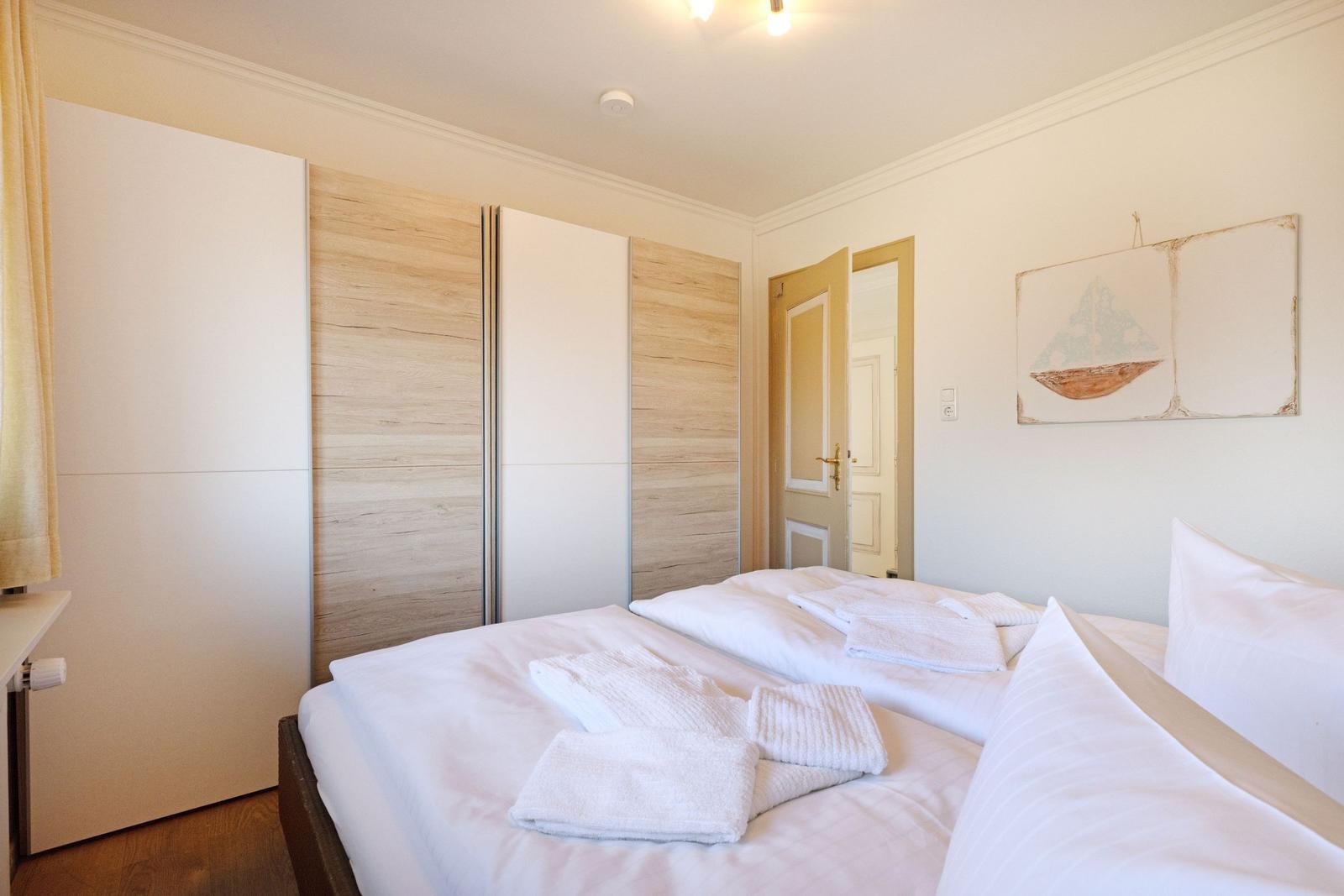Schlafzimmer mit Doppelbett, Kleiderschrank und Wandbild