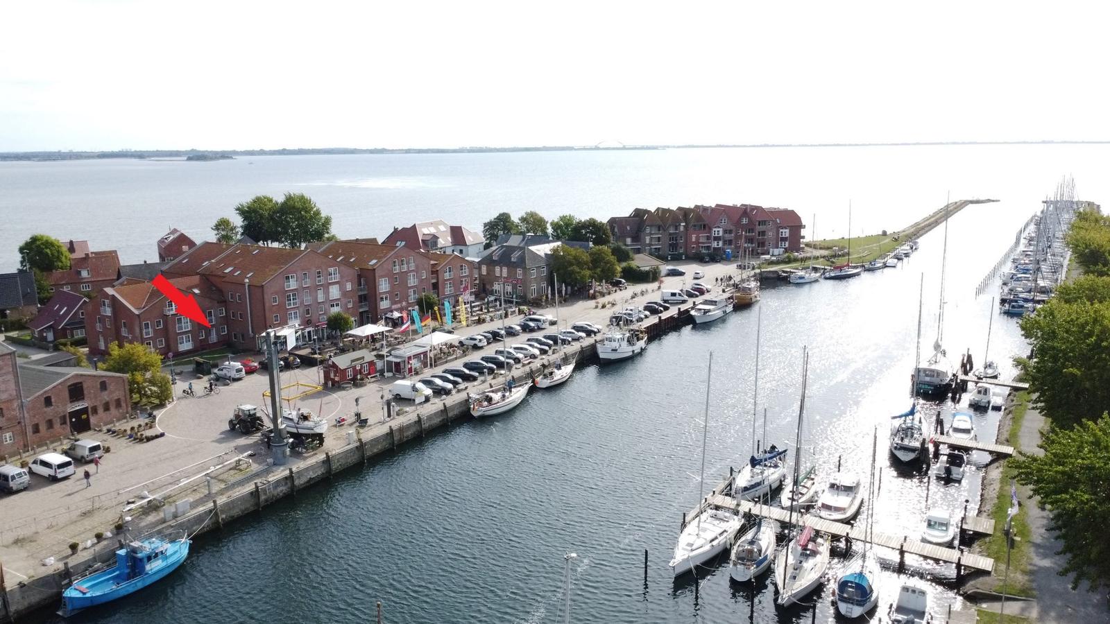 Hafen mit Booten und roten Häusern an der Wasserkante.