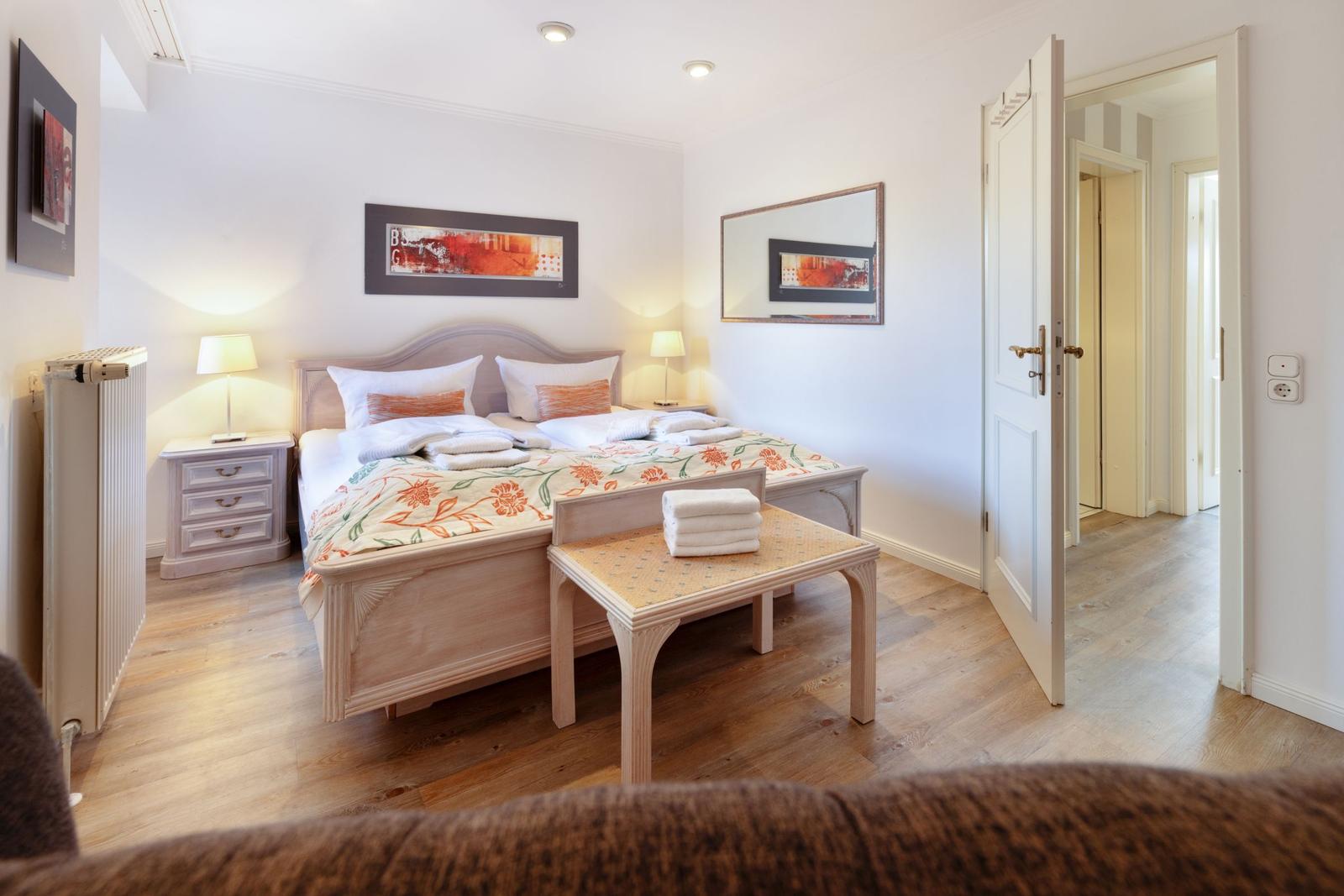Bedroom with bed, nightstands, and decorative pictures on the walls.