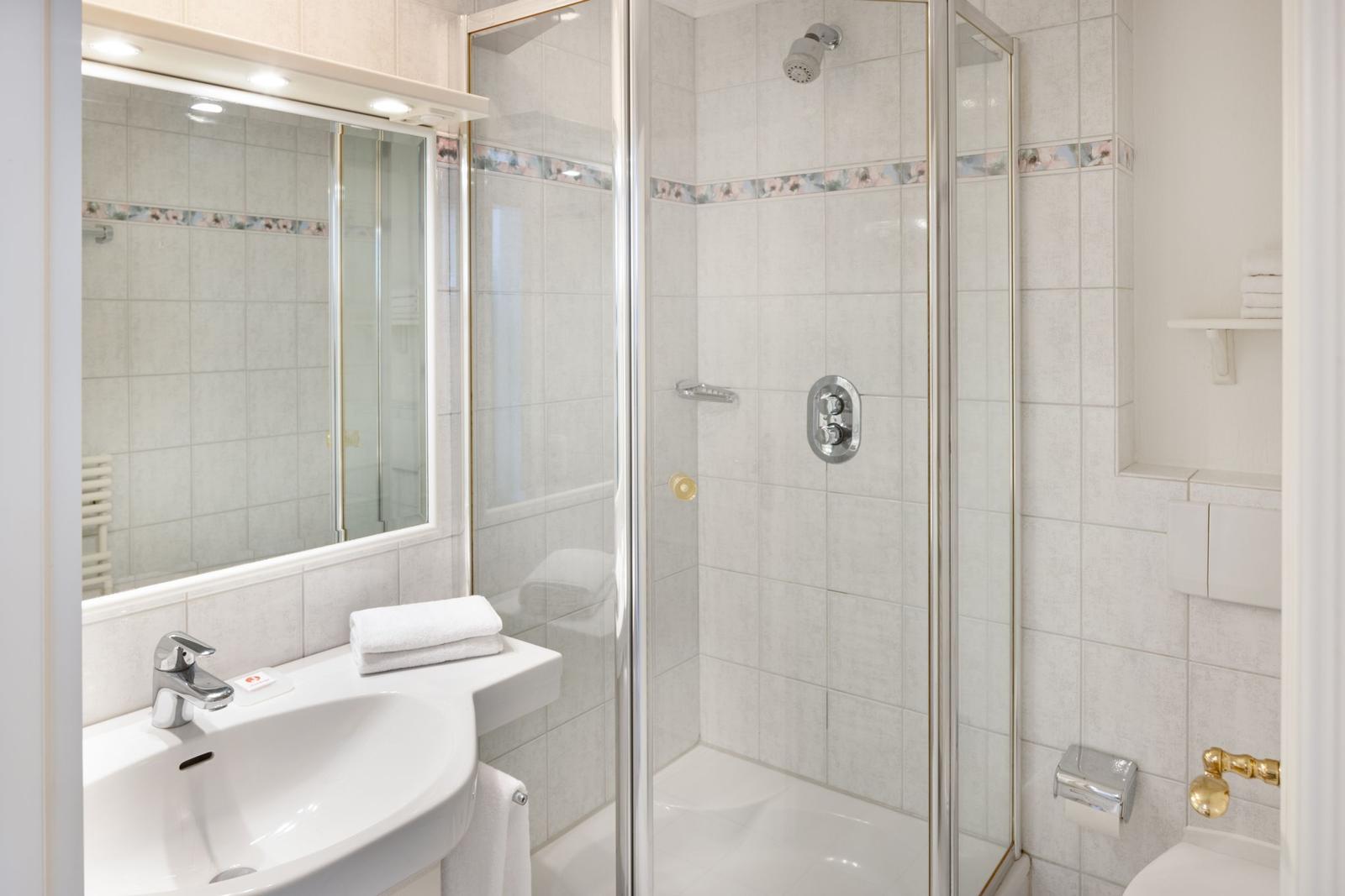 Bathroom with shower, sink, and mirror.