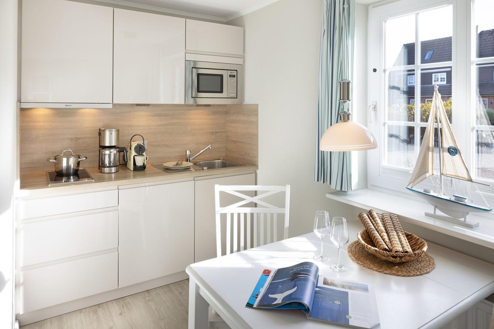 Kitchen with dining area, window, and sailboat model