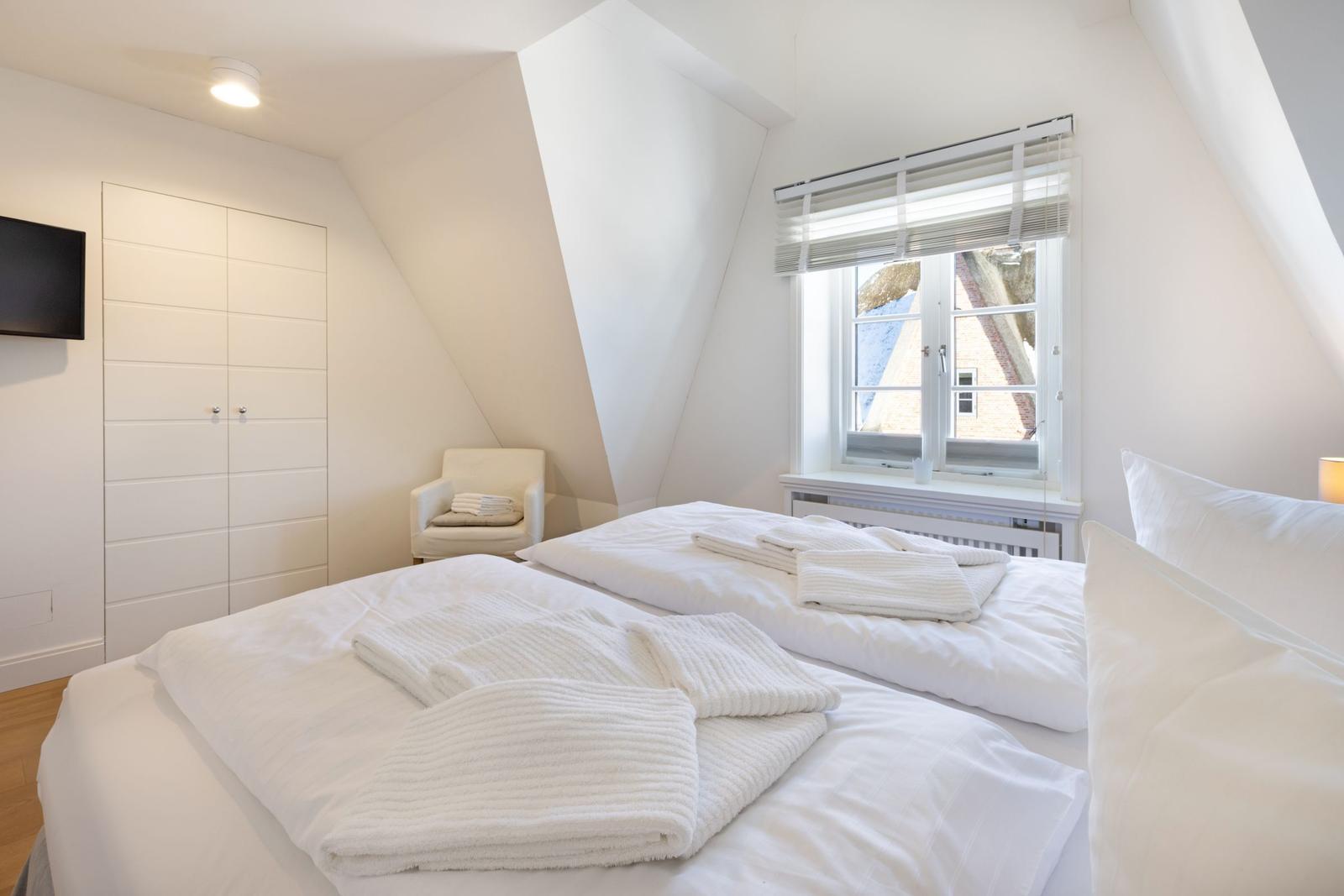 Schlafzimmer mit Doppelbett, Fenster und Kleiderschrank