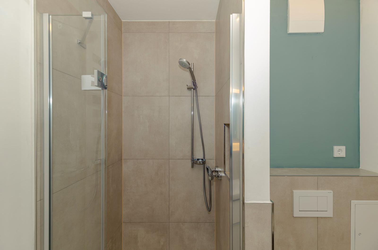 Dusche mit Glaswand und Duschbrause an Wand montiert