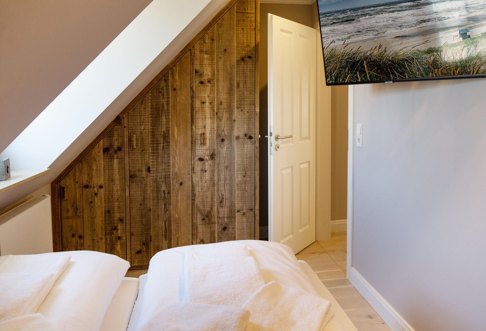 Schlafzimmer mit Holzwand, Bett und Wandbild