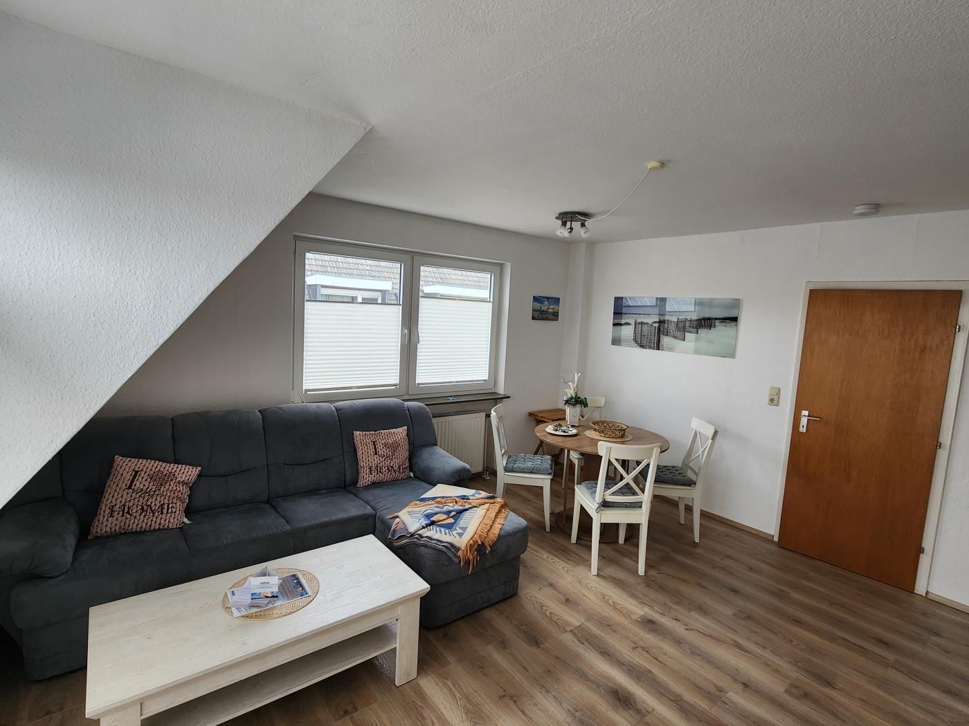 Wohn- und Essbereich mit Sofa, Esstisch und Holzboden