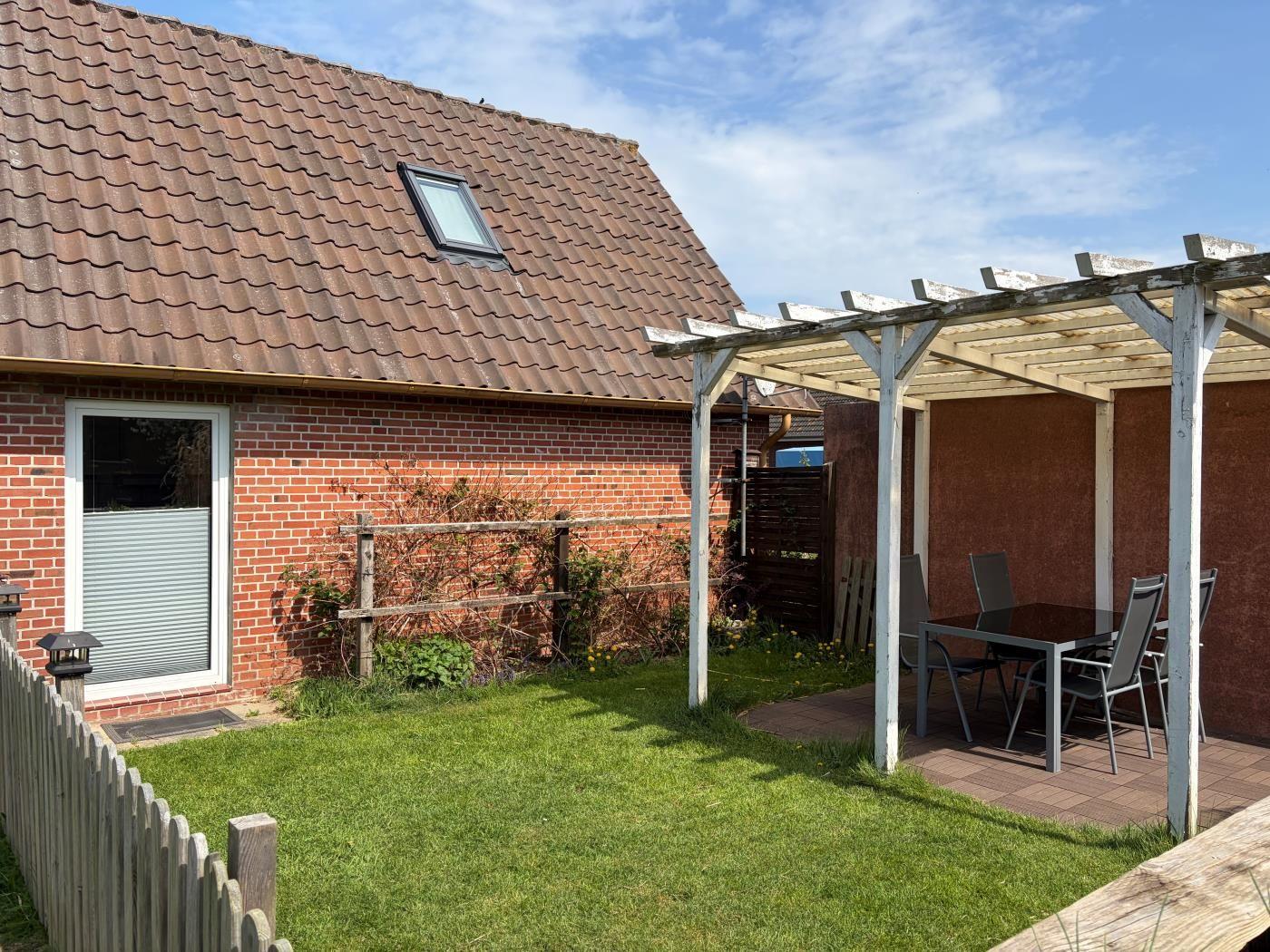 Haus mit Garten, Terrasse und Pavillon. Garten mit Rasen und Pflanzen.