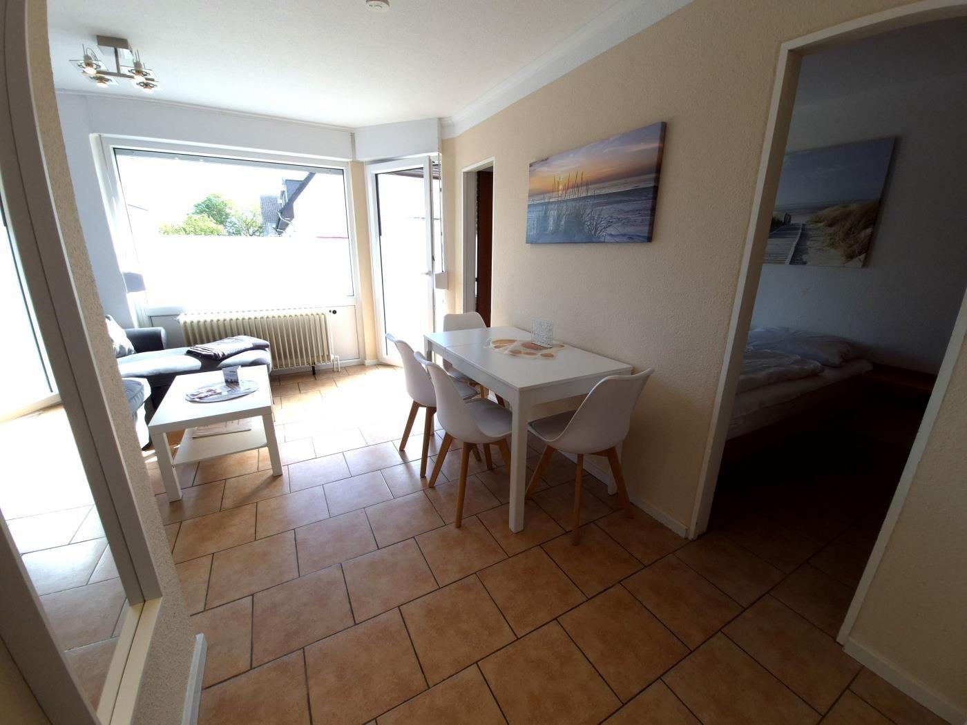 Wohn- und Essbereich mit Terrasse. Schlafzimmer im Hintergrund.