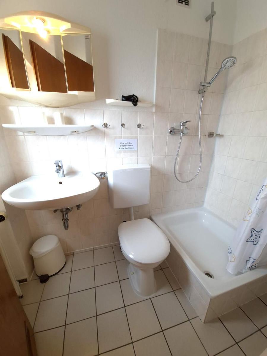 Badezimmer mit Badewanne, Dusche, Toilette und Waschbecken.