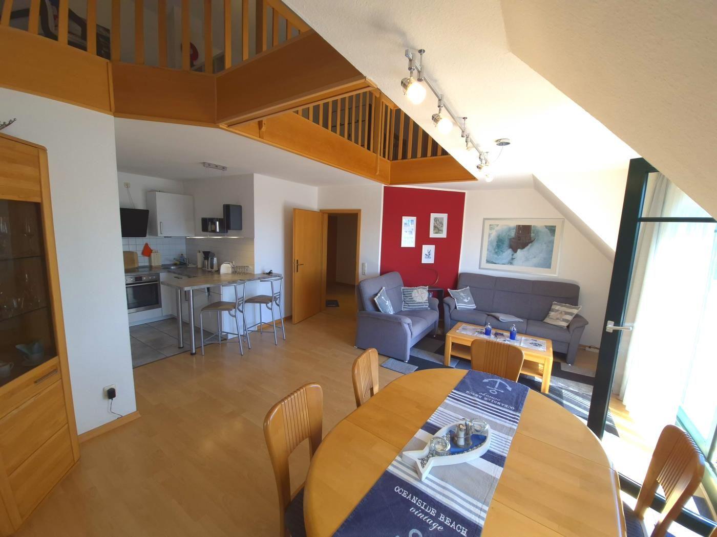 Wohnung mit Essbereich, Küche und Wohnzimmer unter Dachschrägen.