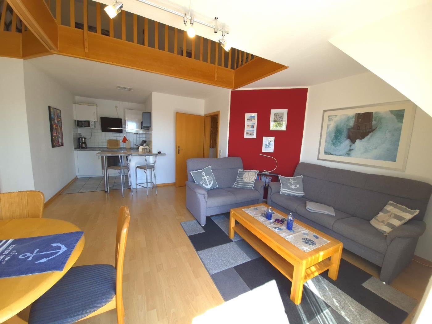 Wohnung mit Essbereich, Wohnzimmer und Küche unter Holzdecke.
