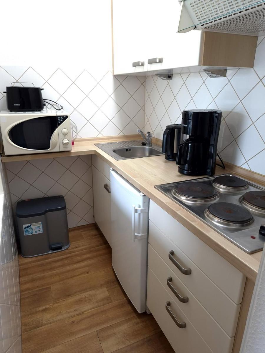 Küche mit Herd, Kühlschrank, Spüle und Mikrowelle