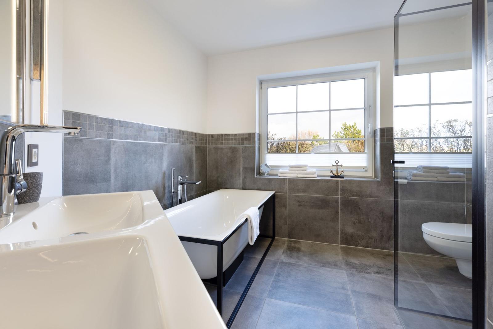 Badezimmer mit Badewanne, Duschbad und Fensterblick